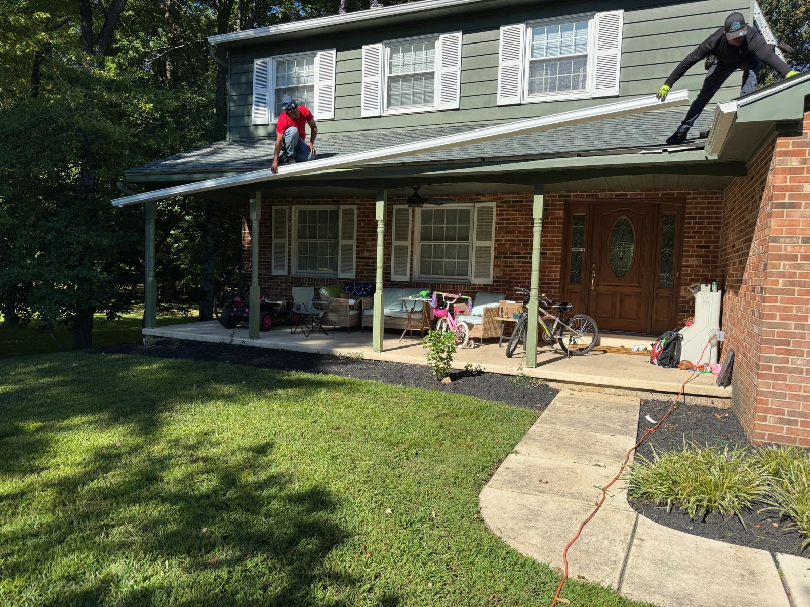 Altieri and Sons crew member working on roof of home with covered porch