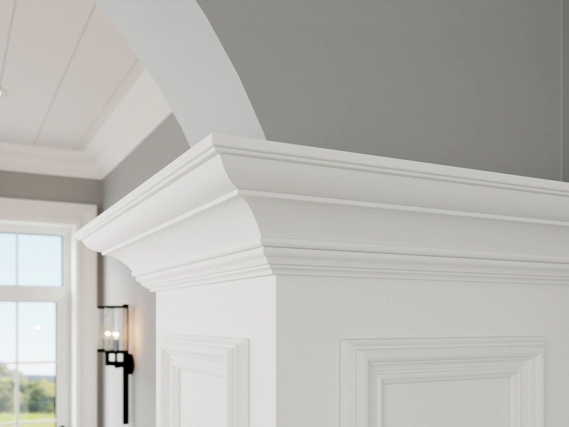 Custom white crown moulding detail on cabinetry with arched doorway