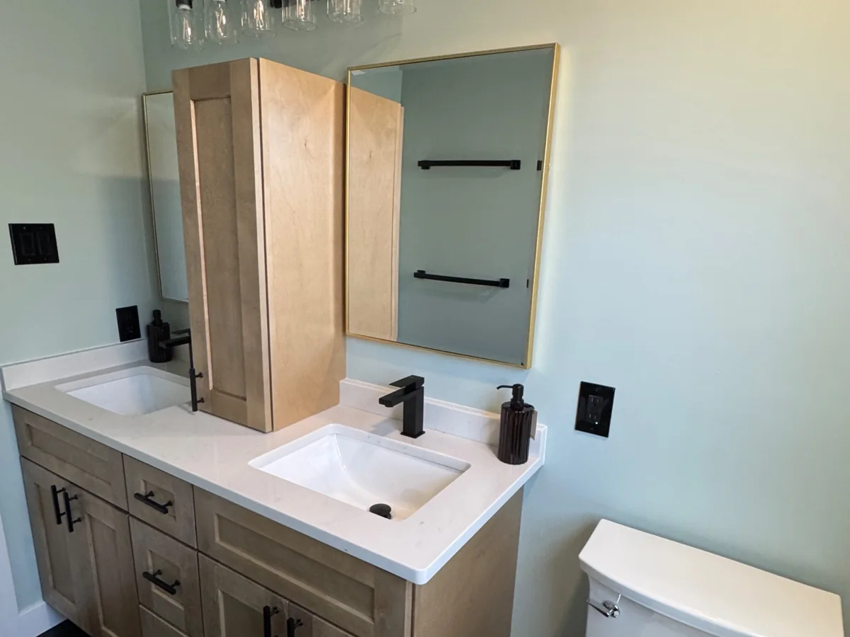 Renovated bathroom with light wood double vanity, white quartz countertops and matte black fixtures by Altieri and Sons in Bucks County PA