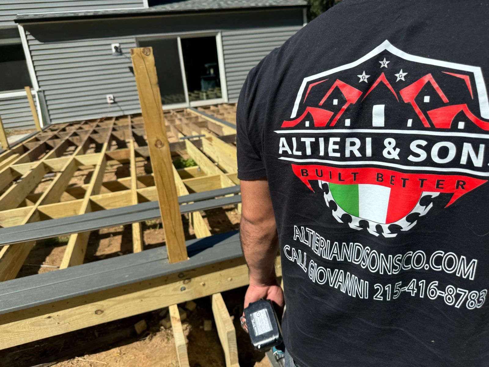 Crew member in Altieri and Sons branded shirt framing a new deck