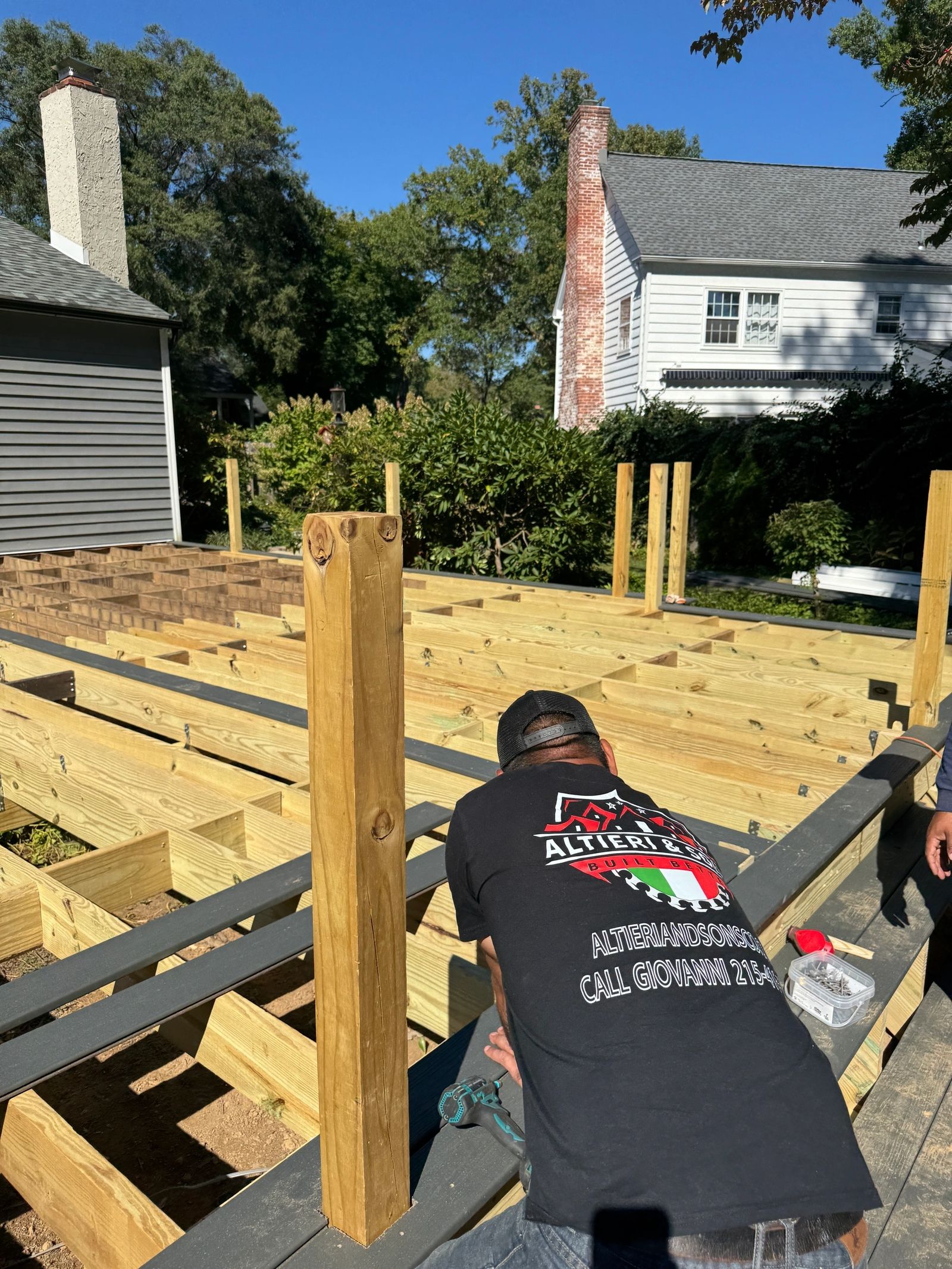 Altieri and Sons crew member building deck frame wearing company shirt