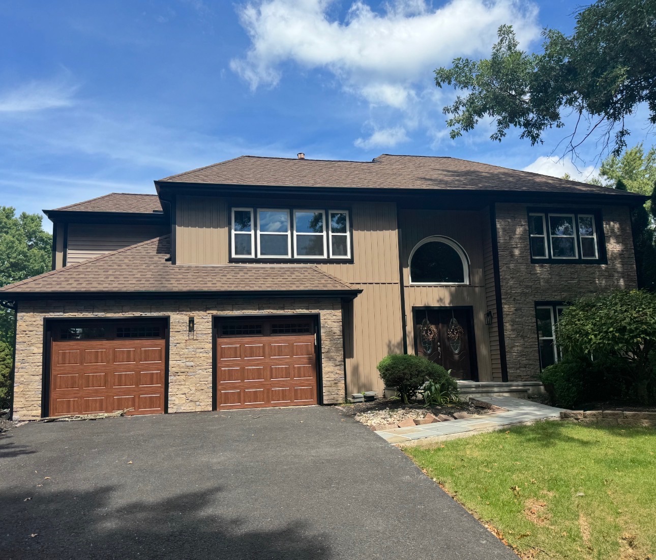 Complete exterior renovation with new siding, stone veneer and garage doors by Altieri and Sons