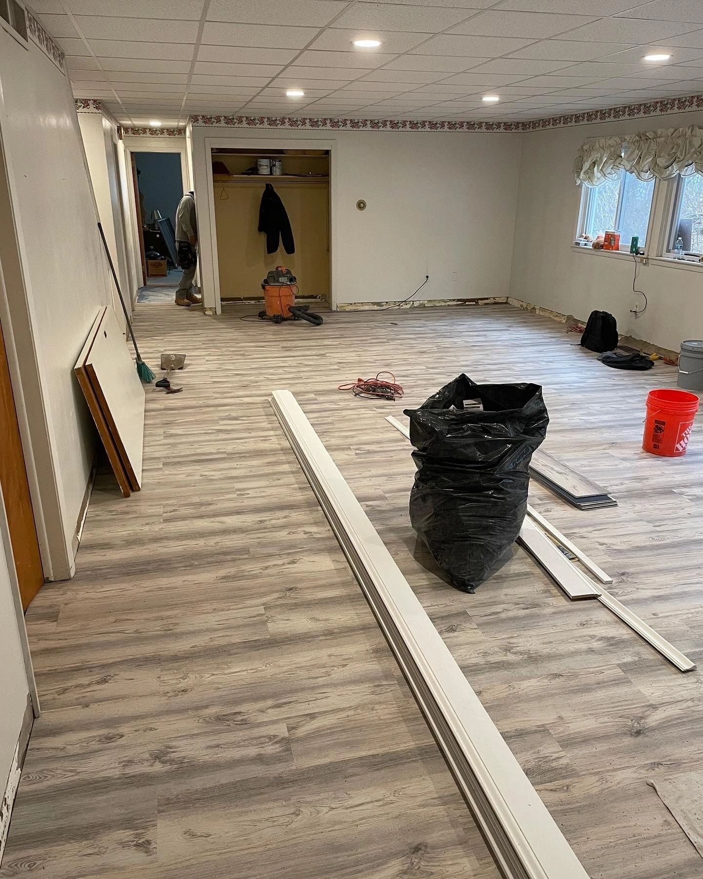 LVP flooring installation in progress in basement recreation room