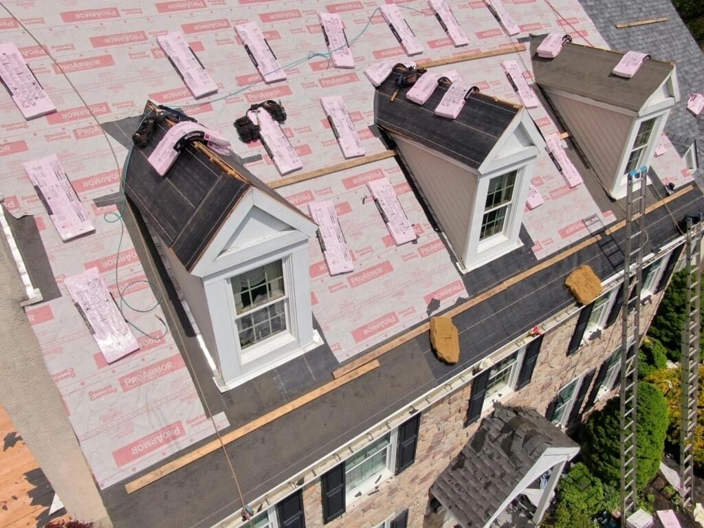Aerial drone view of roof replacement in progress with ProArmor underlayment on dormer windows