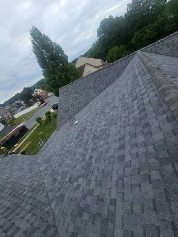 Close-up of completed architectural shingle roof overlooking residential neighborhood