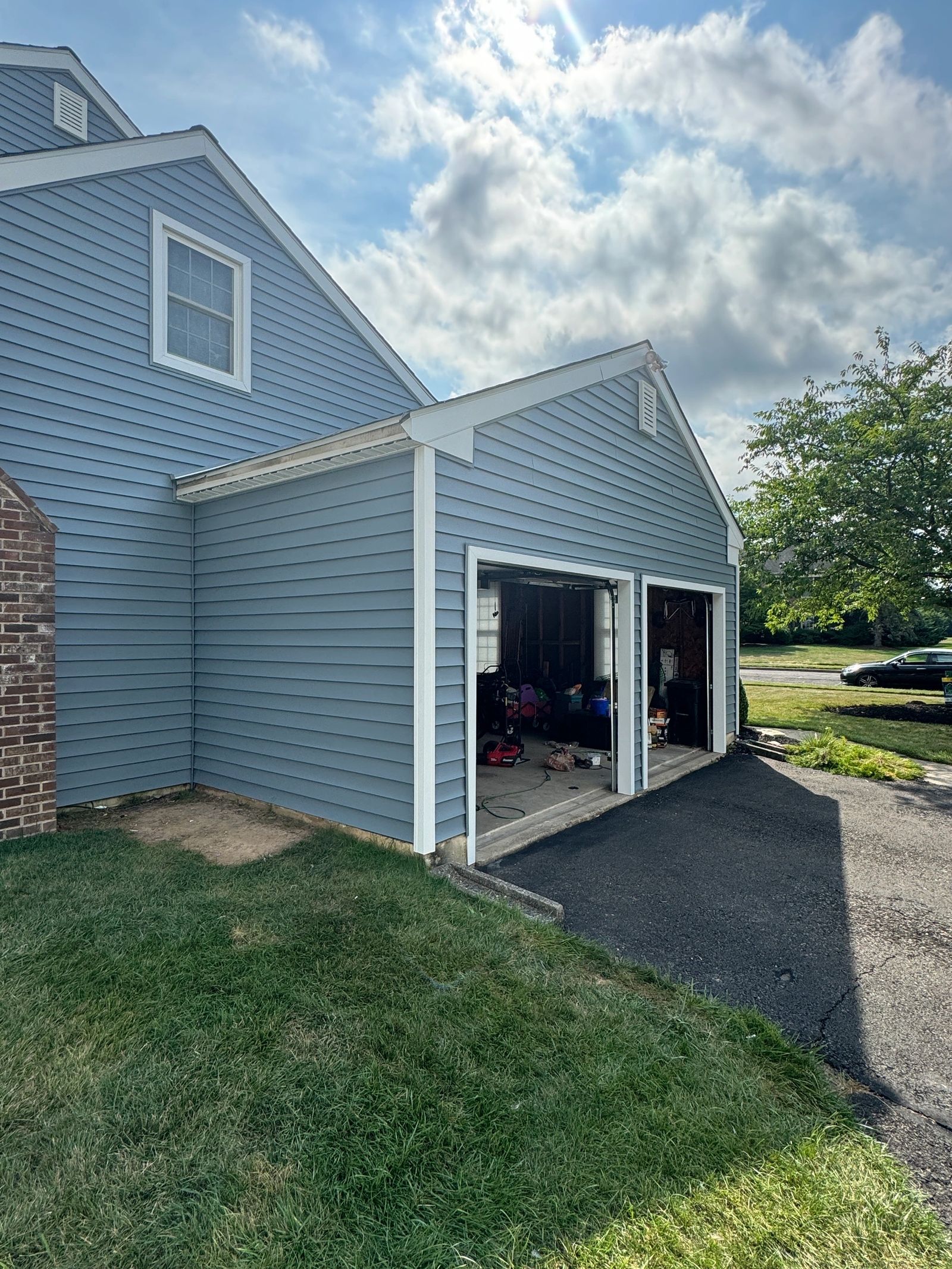 Completed blue vinyl siding installation on home with attached garage