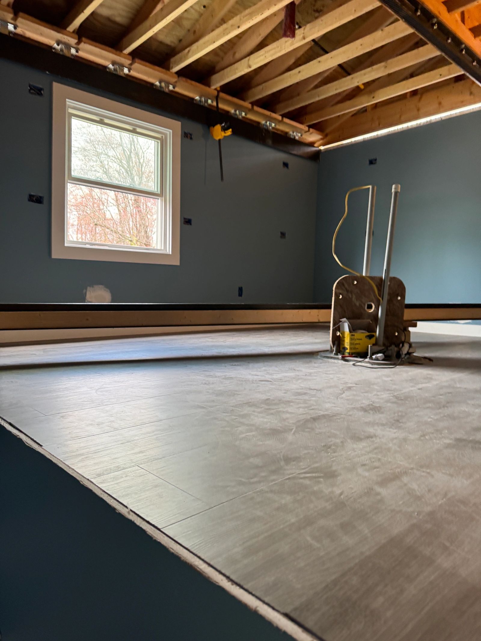Room renovation showing new window and flooring installation in progress