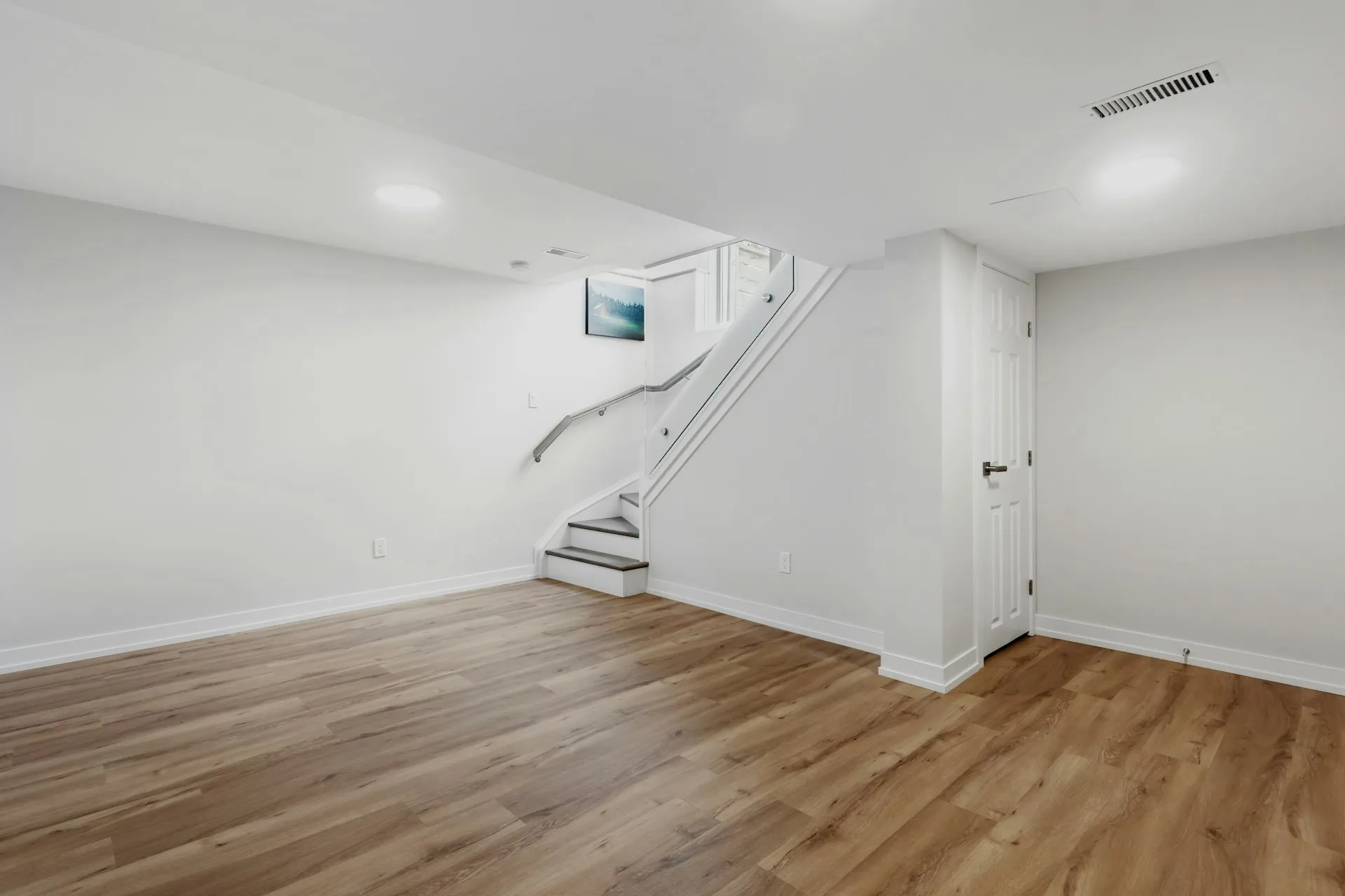 Finished basement with staircase and hardwood floors