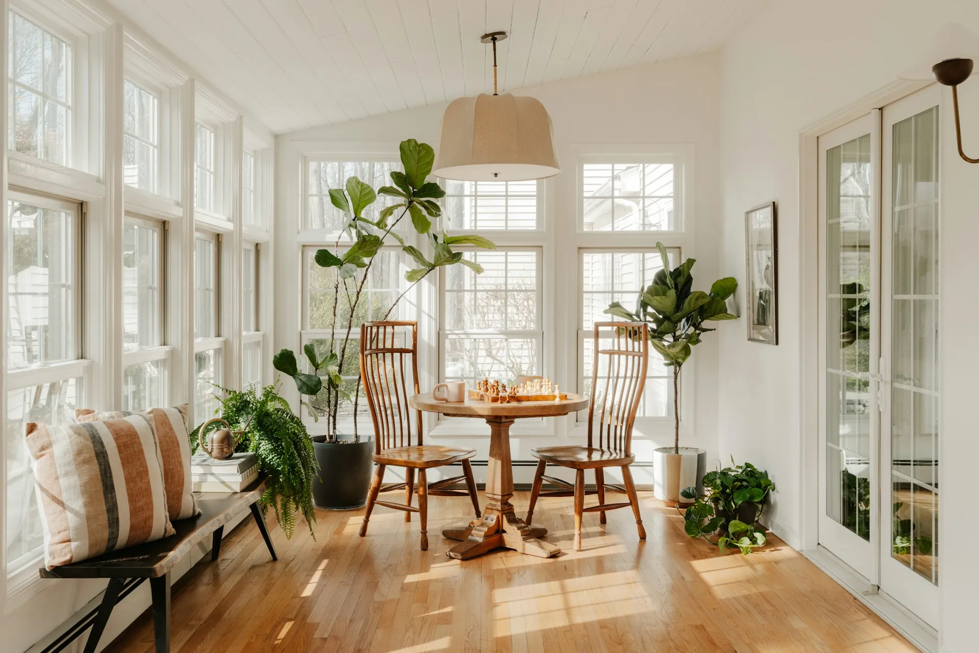 Bright sunroom with dining table and plants
