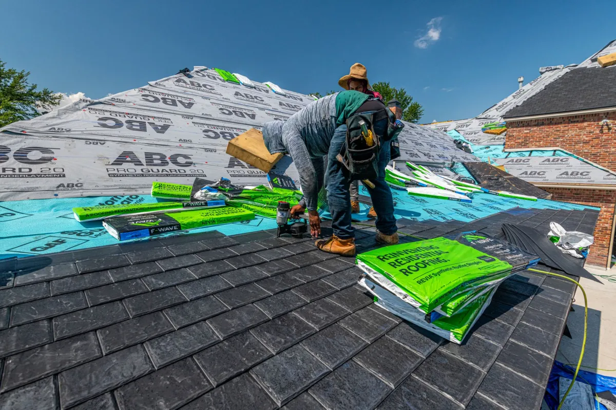 Professional roofer installing shingles on a residential home