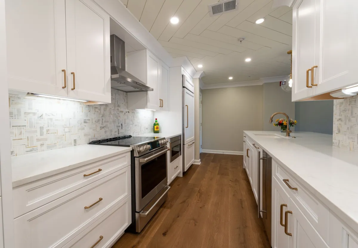 Remodeled kitchen with white cabinets and stone countertops